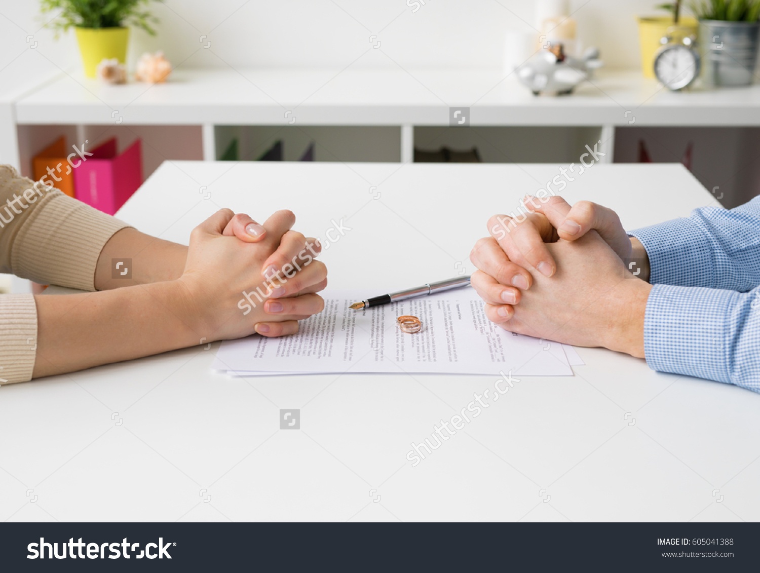 stock-photo-couple-going-through-divorce-signing-papers-605041388.jpg